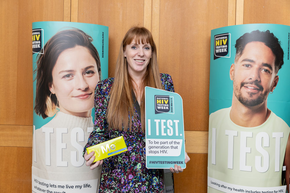 Angela Rayner MP in front of National HIV Testing Week posters, holding a test kit