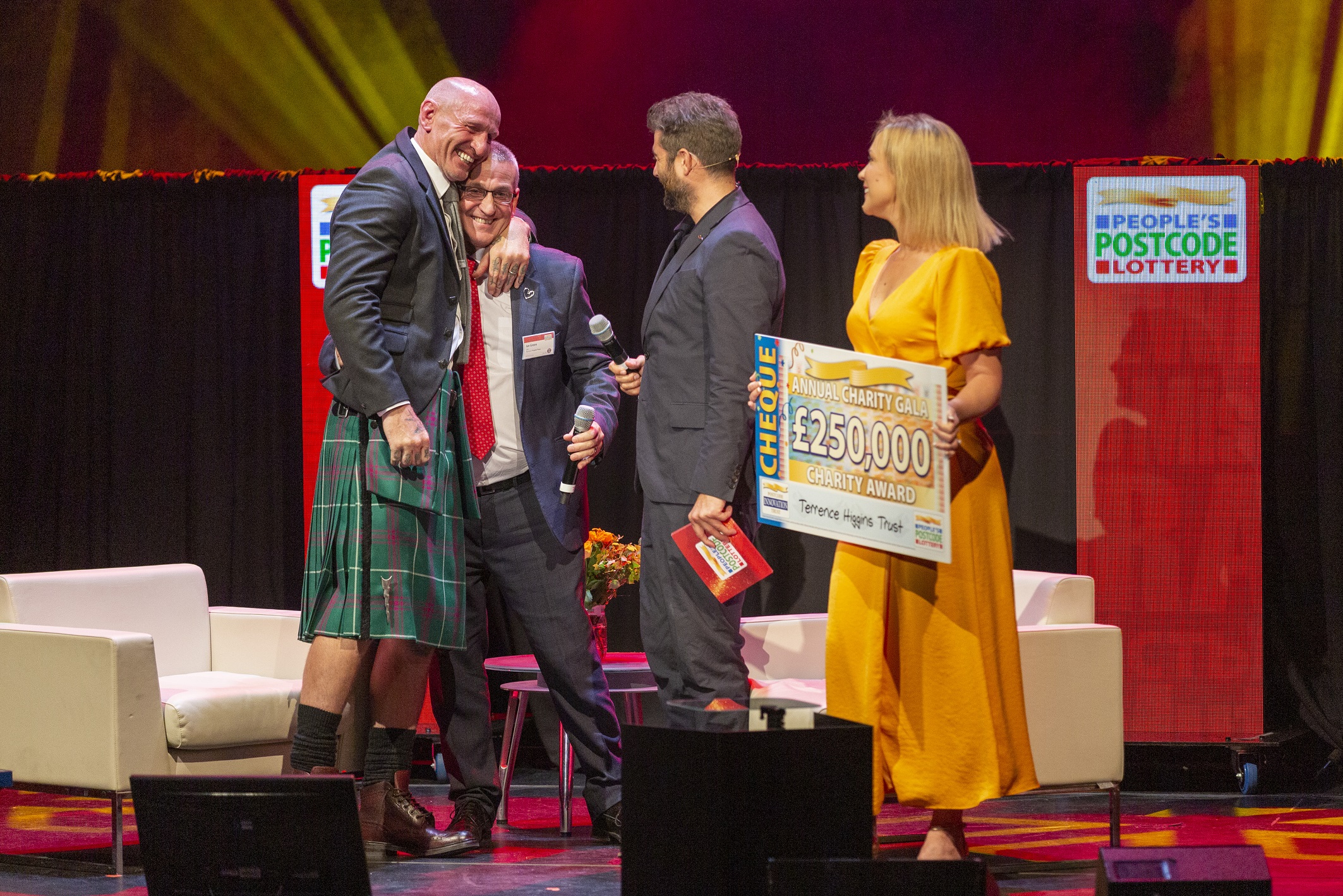 Gareth Thomas on stage with Ian Green at People's Postcode Lottery Charity Gala getting Postcode Hero award