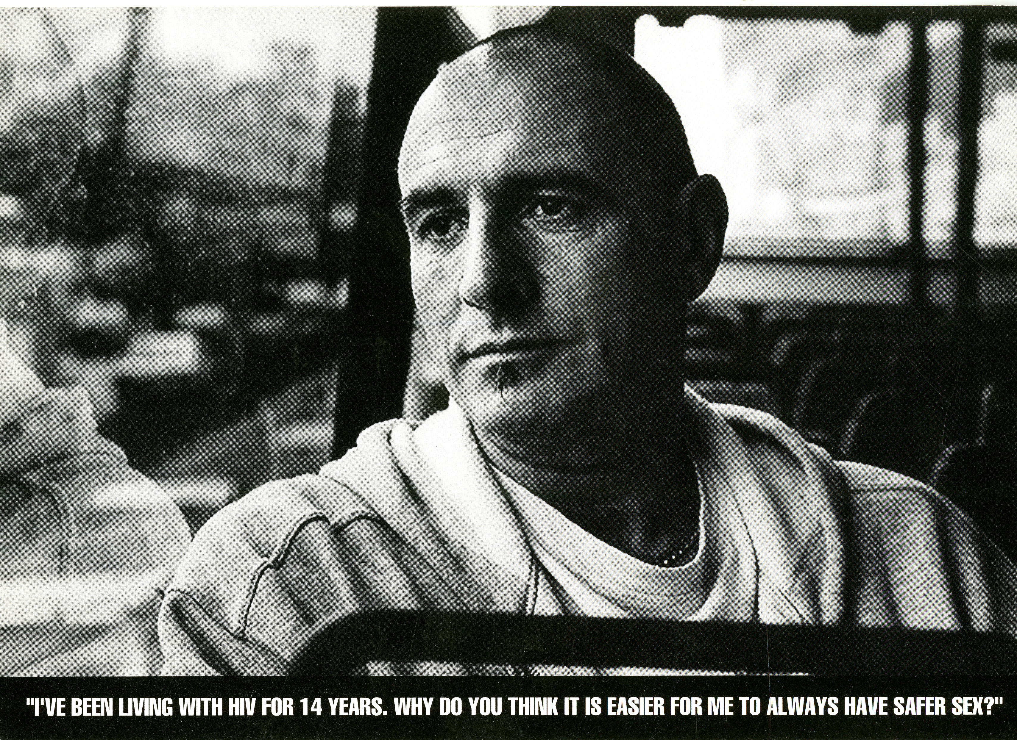 Black and white postcard of Jonathan Burke. Underlying caption "I've been living with HIV for 14 years. Why do you think it is easier for me to always have safer sex?"