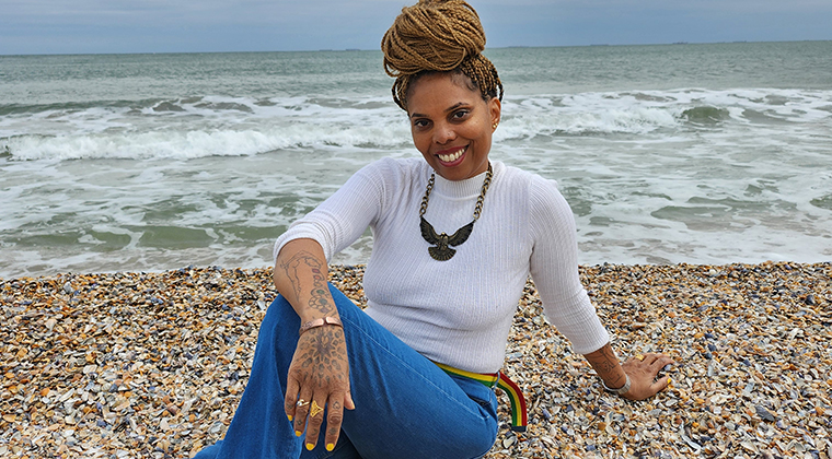 Louise Vallace sat on a beach, smiling