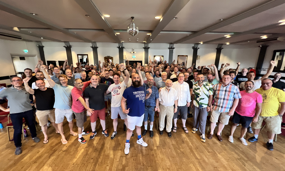 Mark inside a hall with group of supporters of his Thames Path Challenge