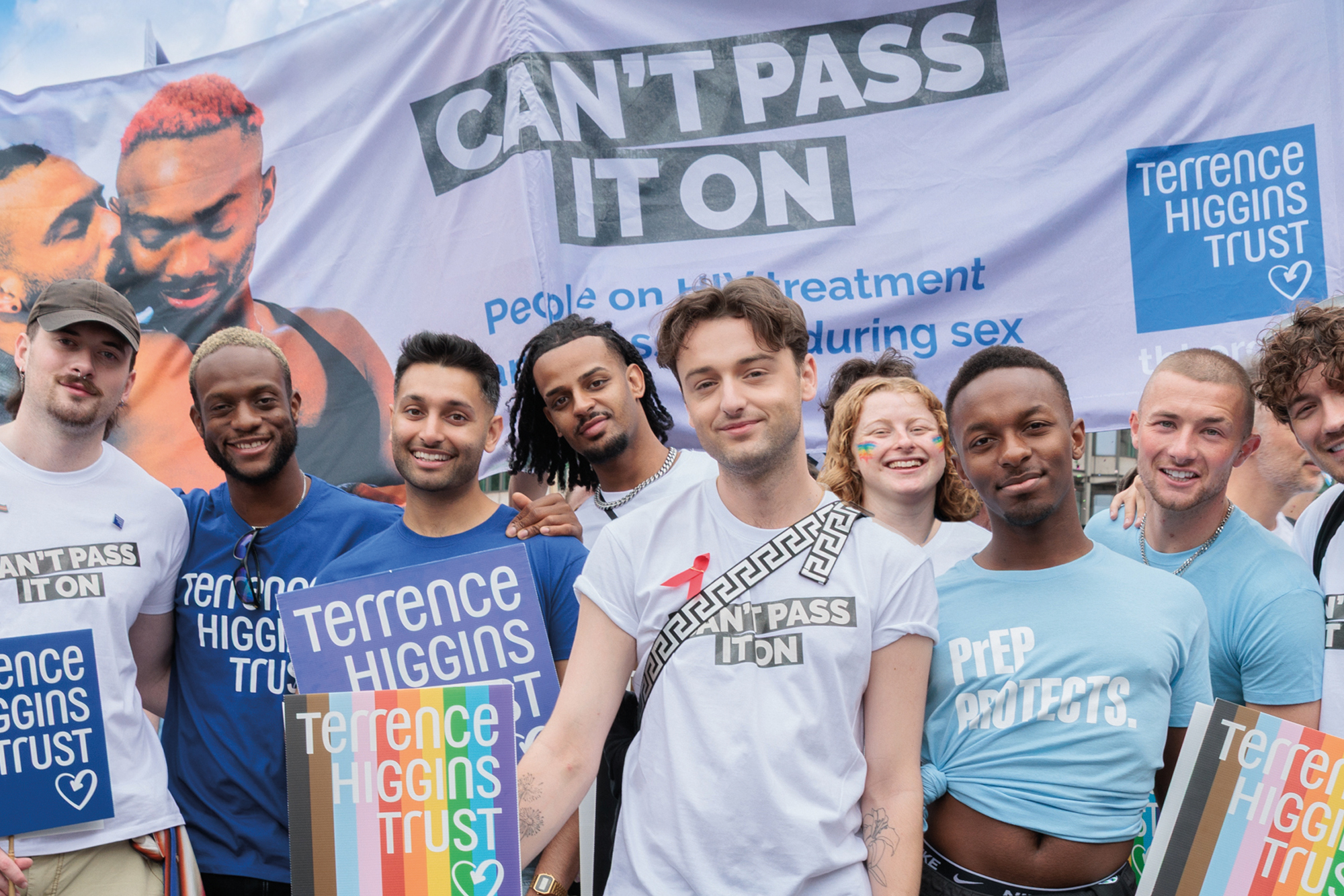 Adam from I Kissed a Boy and a group of people and Can't Pass It On banner