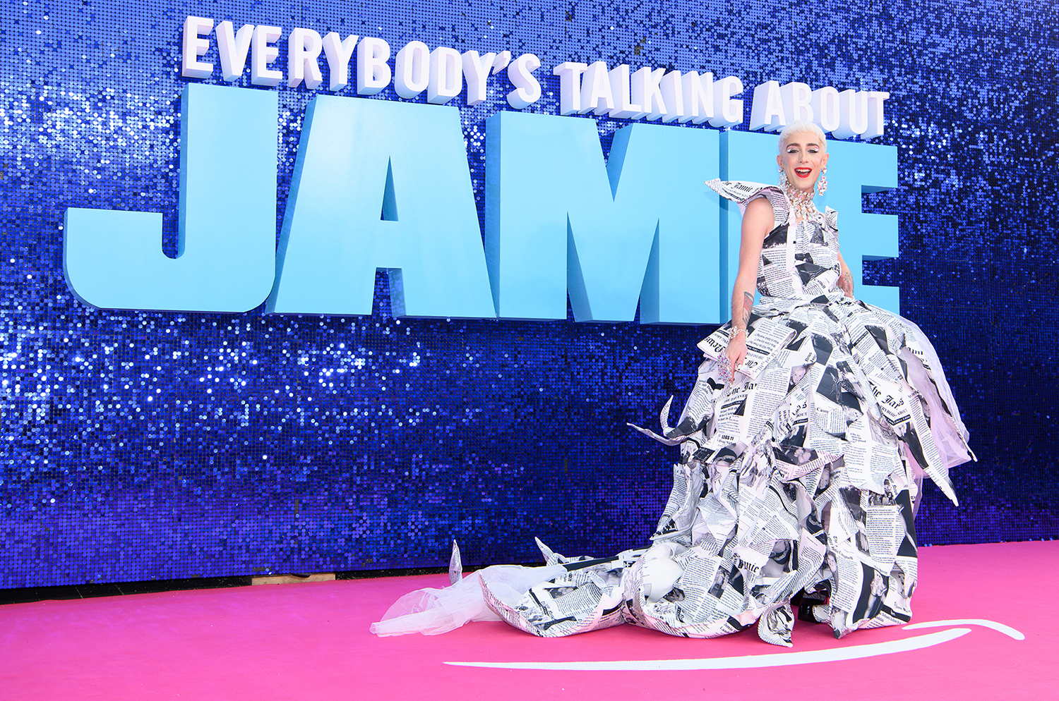 Jamie Campbell in front of the Everybody's Talking About Jamie logo