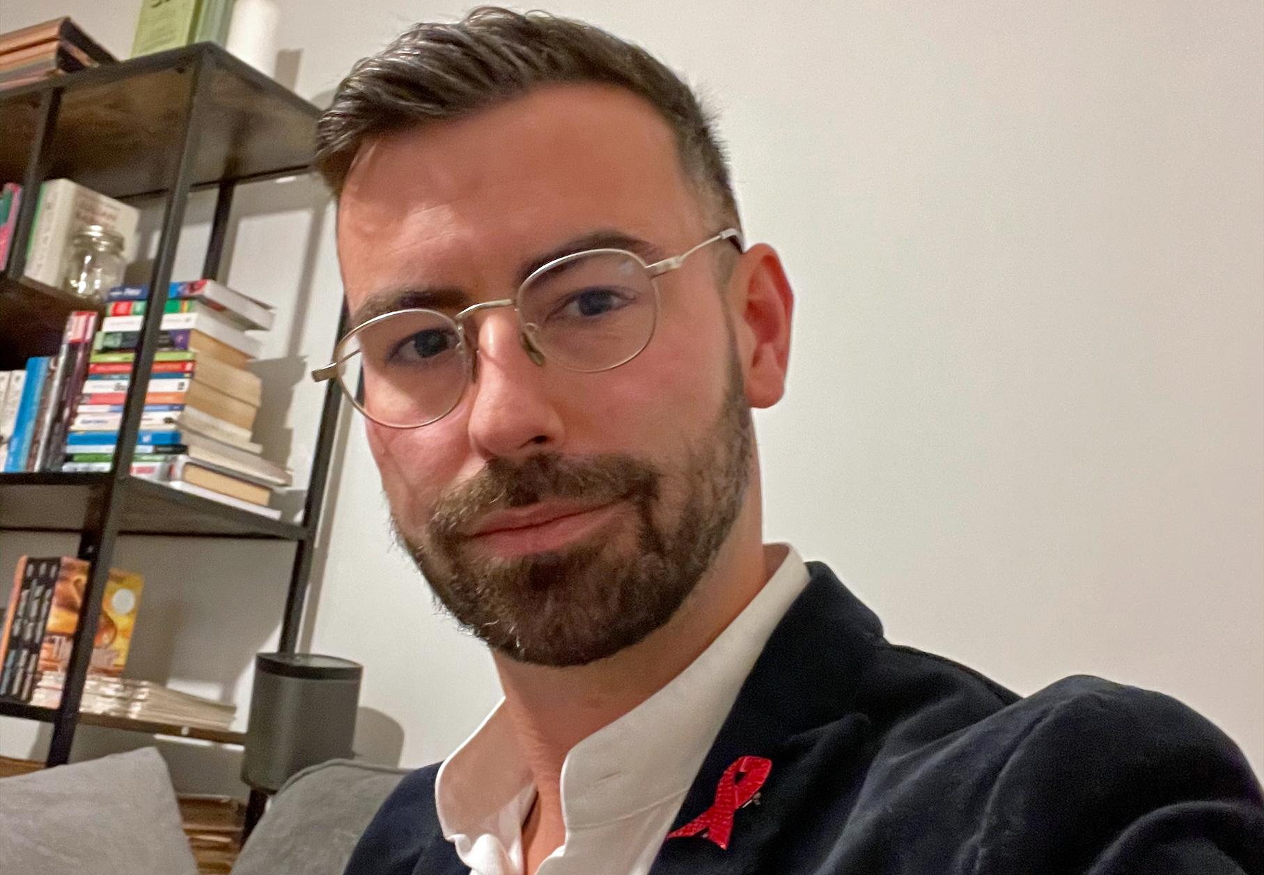 Rhys Goode at home with red ribbon enamel badge