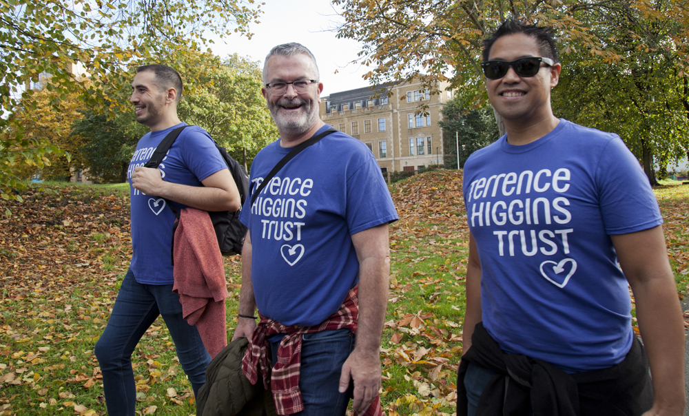 Three men walking in Ribbon Walk with trees in background Three men walking in Ribbon Walk with trees in background