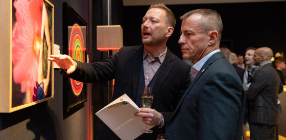 Two men discussing a painting.