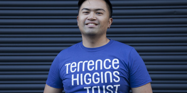 A smiling man wearing a Terrence Higgins Trust t-shirt.
