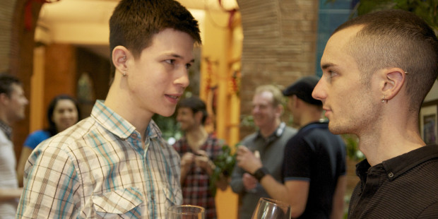 Two men talking over glasses of wine