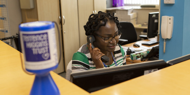 Volunteer on the phone in Terrence Higgins Trust reception