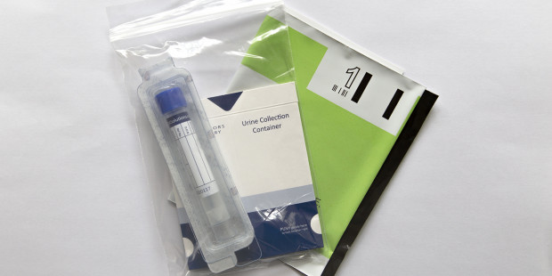 Chlamydia postal testing kit with collection tube and return envelope