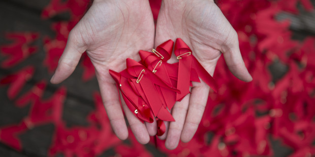 A hand holding red ribbons