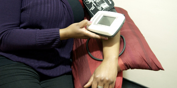 Woman checking her own blood pressure