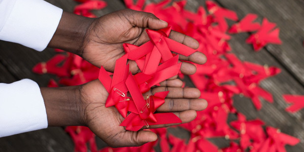 World AIDS day red ribbons in hands World AIDS day red ribbons in hands