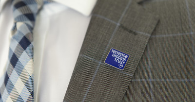 Terrence Higgins Trust lapel pin on a suit jacket
