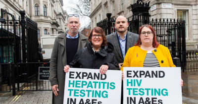 Stuart Smith, Vanessa Hebditch, Richard Angell and Deborah Gold holding signs saying 'Expand hepatitis testing in A&Es' and 'Expand HIV testing in A&Es' outside Downing Street. 