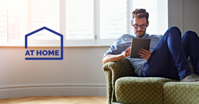Man on sofa reading on a tablet - At Home