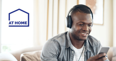 Man with headphones looking at his mobile phone - At Home