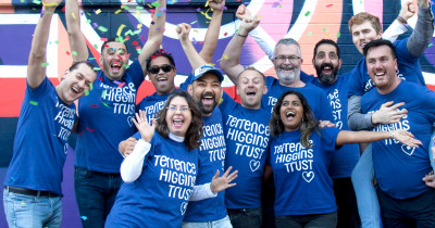 Terrence Higgins Trust celebrating group in front of wall