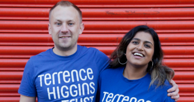 A man with his arm around a woman, both in Terrence Higgins Trust t-shirts.