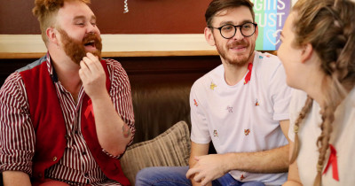 People wearing red ribbons chatting on the sofa People wearing red ribbons chatting on the sofa