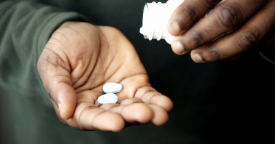 Man tipping pills into his hand