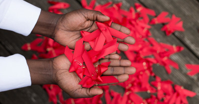 World AIDS day red ribbons in hands World AIDS day red ribbons in hands