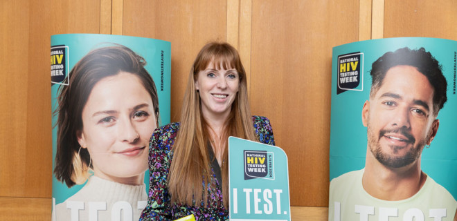 Angela Rayner MP in front of National HIV Testing Week posters, holding a test kit