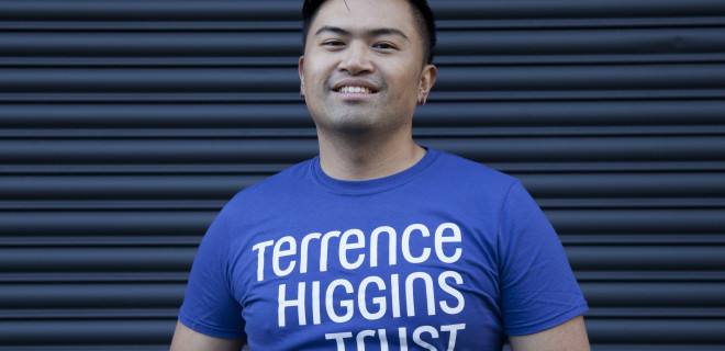 A smiling man wearing a Terrence Higgins Trust t-shirt.