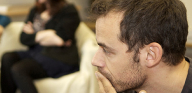 Man looking worried with other people in the background