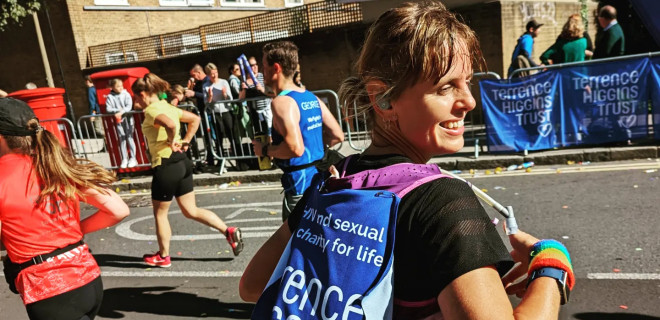 Emma running London Marathon 2022 with Terrence Higgins Trust banner on back