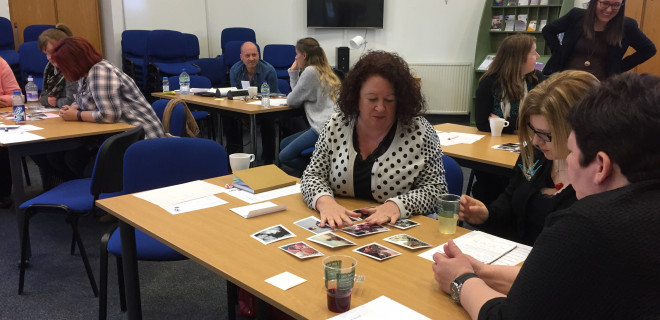 People sitting round tables during a training session.