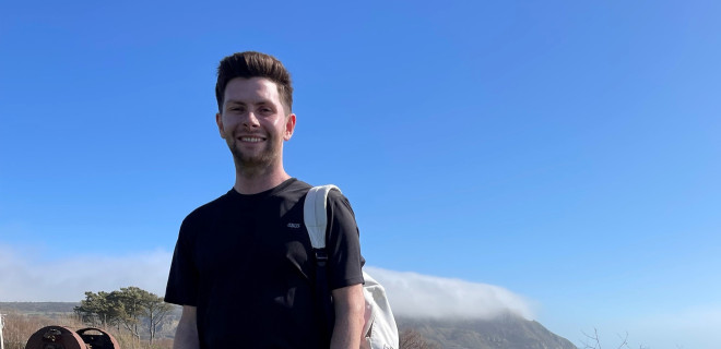 Matt Ankers stands by the coast smiling.