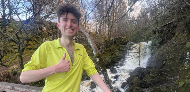 Tomas in training gear on bridge, giving thumbs up