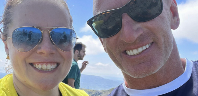 Christine with Gareth Thomas on the summit with blue sky behind them