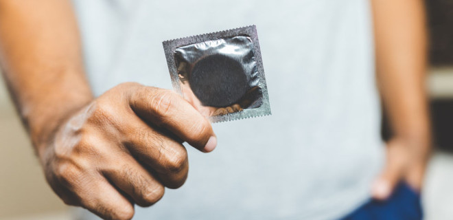 A person holding a condom.
