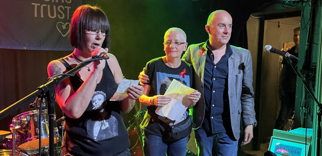 Three people on a stage at David Bowie fundraising night