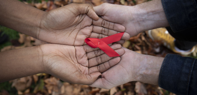 Red ribbon held by four hands