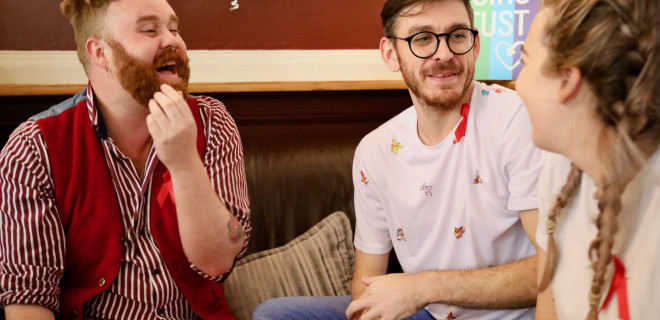People wearing red ribbons chatting on the sofa