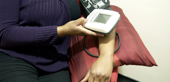 Woman checking her own blood pressure