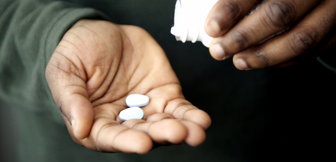 Man tipping pills into his hand