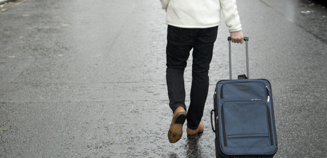 Man wheeling a suitcase