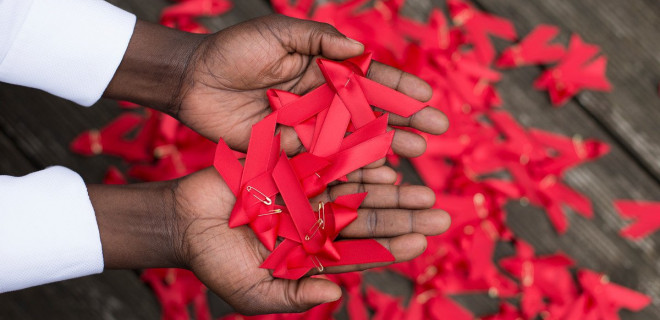 World AIDS day red ribbons in hands