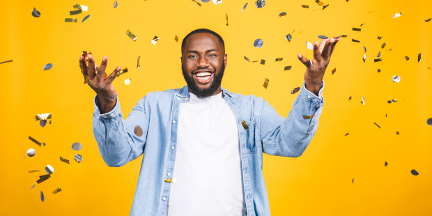A man in a celebratory pose, smiling.