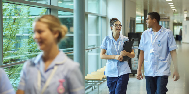 Healthcare professionals walking along corridor