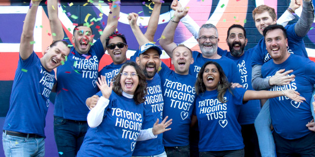 Terrence Higgins Trust celebrating group in front of wall