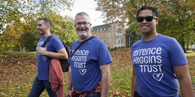 Three men walking in Ribbon Walk with trees in background