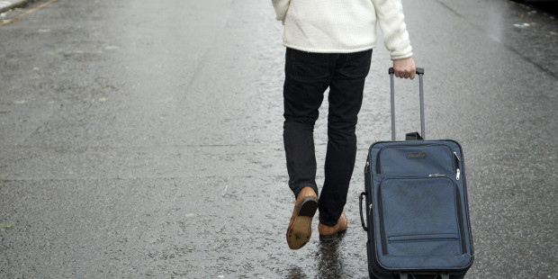 Man wheeling a suitcase
