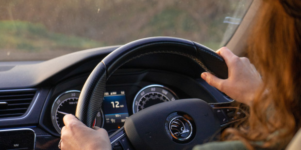 A woman holding the steering wheel of a car