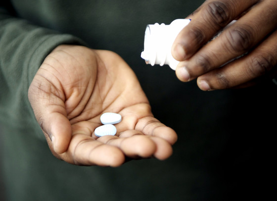 Man tipping pills into his hand