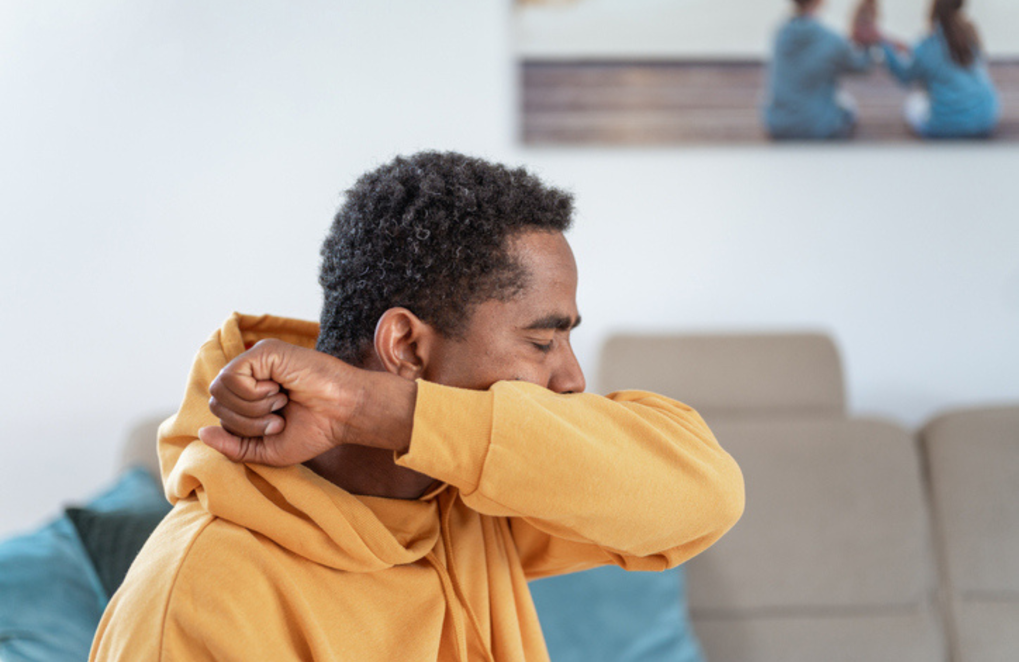 Man coughing into his arm